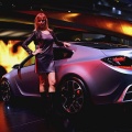 Models stand next to the Opel GTC cocept at the 77th International Motor Show